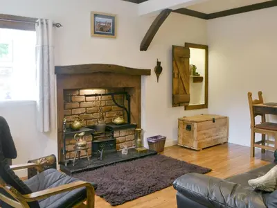 a living room with a fireplace and a couch at The Cottage in Blackwood