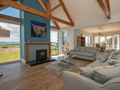 a living room with couches and a fireplace at Quarter Acre House in Challoch