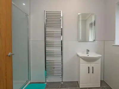 a bathroom with a sink and a shower at Quarter Acre House in Challoch