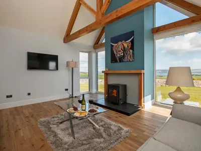 a living room with a couch and a fireplace at Quarter Acre House in Challoch