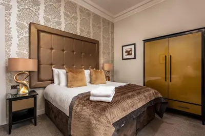 a bedroom with a large bed with a large headboard at The Kylestrome in Ayr