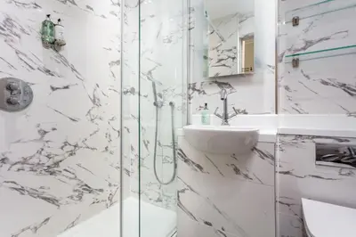 a white bathroom with a sink and a shower at The Kylestrome in Ayr