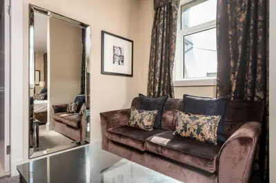 a living room with a brown couch and a mirror at The Kylestrome in Ayr