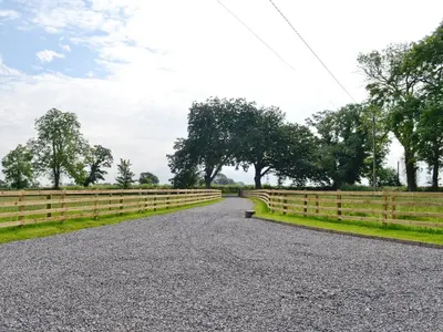 a gravel road with a fence on the side at Bruno's Bothy in Wigton
