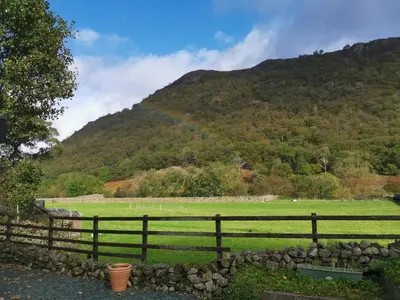 a rainbow over a field with a fence at The Langstrath Country Inn in Keswick