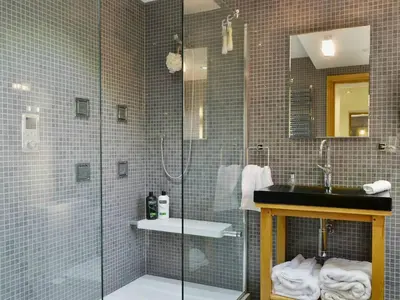 a bathroom with a glass shower and a sink at Saddleback Penthouse in Penrith