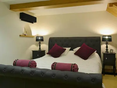 a bedroom with a large bed with red pillows at Saddleback Penthouse in Penrith
