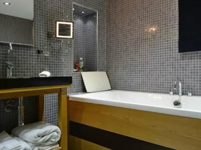 a bathroom with a bath tub and a sink at Saddleback Penthouse in Penrith
