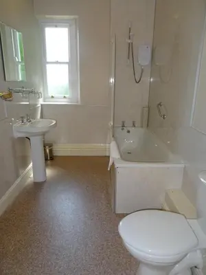 a bathroom with a toilet and a tub and a sink at Lutwidge Arms in Holmrook