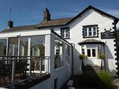 a white building with large windows and a balcony at Lutwidge Arms in Holmrook