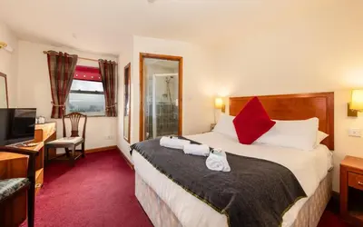a hotel room with a bed and a television at The Red Admiral Gosforth CA20 1BP in Seascale
