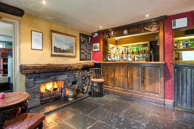 a bar with a fireplace and a fire place at The Traveller's Rest in Grasmere