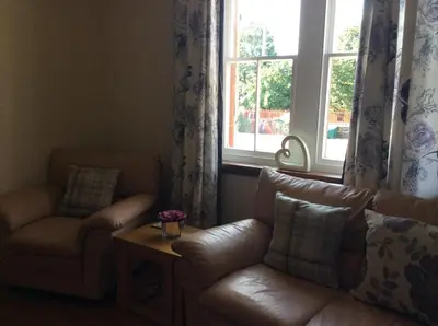a living room with a couch and a chair and a window at St Matthews cottages in Allonby
