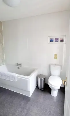 a bathroom with a white tub and a toilet at The Mariner Hotel in Kippford