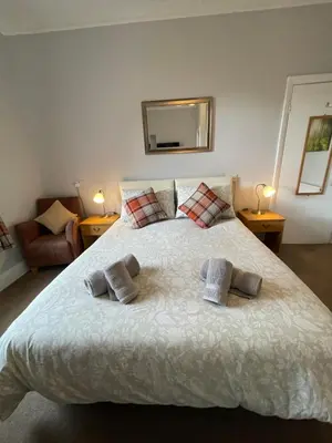 a bedroom with a large bed with two towels on it at Rivendell Guest House in Keswick