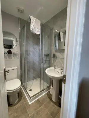 a bathroom with a shower and a toilet and a sink at Rivendell Guest House in Keswick