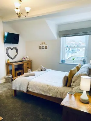 a bedroom with a large bed and a window at Rivendell Guest House in Keswick