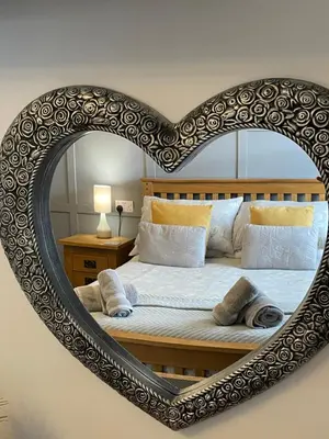 a bed with a heart shaped frame on a wall at Rivendell Guest House in Keswick