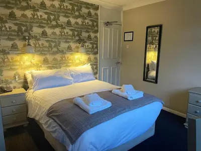 a bedroom with a bed with two towels on it at The Bridge Inn in Holmrook