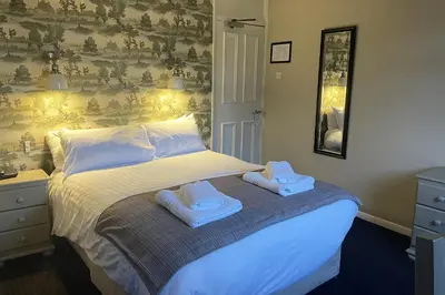 a bedroom with a bed with towels on it at The Bridge Inn in Holmrook