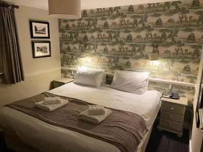 a bedroom with a large bed with two towels on it at The Bridge Inn in Holmrook