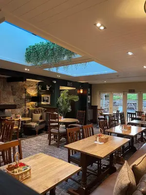 a restaurant with tables and chairs and a large window at The Bridge Inn in Holmrook