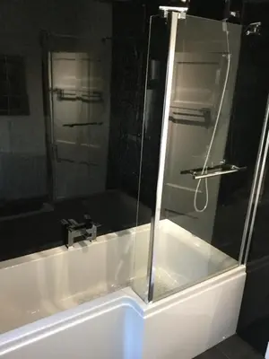 a shower with a glass door in a bathroom at In House Garden Flat in Castle Douglas