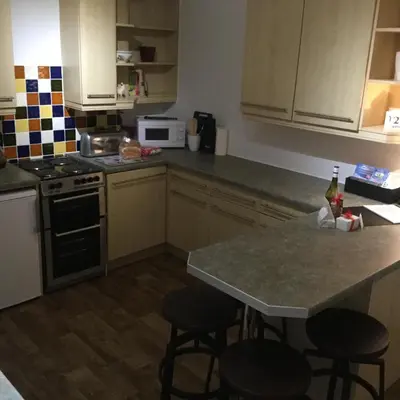a kitchen with a counter and two bar stools at In House Garden Flat in Castle Douglas
