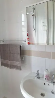 a white bathroom with a sink and a mirror at Dumfries Central apartment in Dumfries