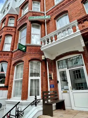 a brick building with a bench in front of it at The Island & Fairfield in Douglas
