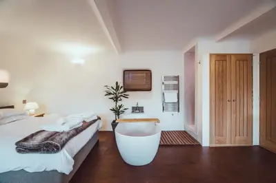 a bedroom with a bath tub and a bed at The Little Fish in Cockermouth