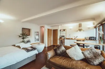 a living room with a couch and a kitchen at The Little Fish in Cockermouth