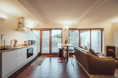 a kitchen and living room with a couch and a table at The Little Fish in Cockermouth