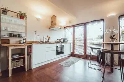a kitchen with white cabinets and a table and a window at The Little Fish in Cockermouth