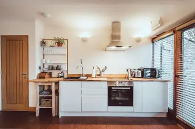 a kitchen with white cabinets and a counter top at The Little Fish in Cockermouth