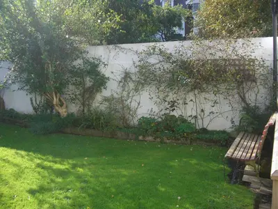 a fence with a bench in a yard with green grass at Blencathra House in Keswick