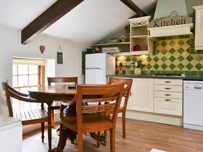 a kitchen with a wooden table and chairs at Lund Cottage Was Gabriel's Cottage in Keswick
