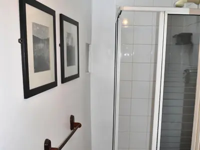 a bathroom with a shower and framed pictures on the wall at Lund Cottage Was Gabriel's Cottage in Keswick