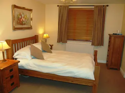 a bedroom with a bed with white sheets and a window at Topsey Turvey in Keswick