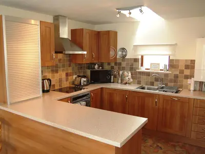 a kitchen with wooden cabinets and a counter top at Topsey Turvey in Keswick