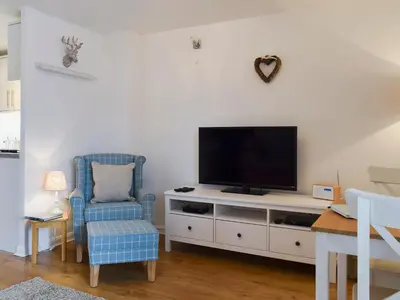 a living room with a tv and a chair at Royal Views in Keswick