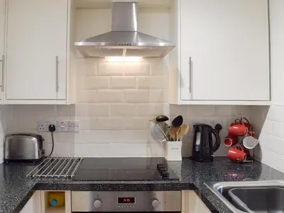 a kitchen with a sink and a stove top oven at 1 Greta Side Court in Keswick