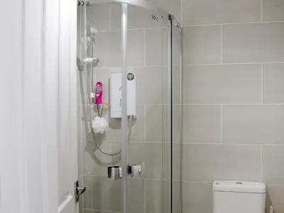 a bathroom with a shower with a glass door at 1 Greta Side Court in Keswick