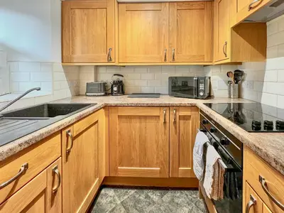 a kitchen with wooden cabinets and a sink at 2 Greta Side Court in Keswick