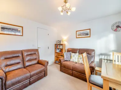 a living room with two leather chairs and a couch at Olivet - Hewetson Court in Keswick
