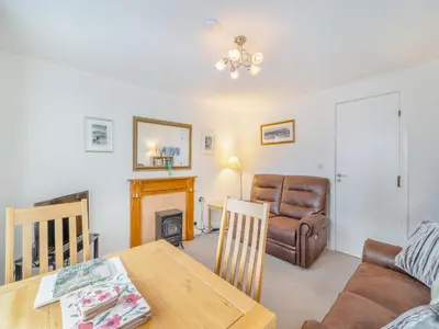 a living room with a table and a couch at Olivet - Hewetson Court in Keswick