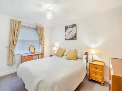 a bedroom with a white bed and a window at Olivet - Hewetson Court in Keswick