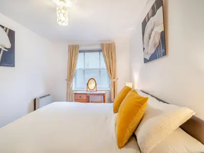 a bedroom with a white bed and a window at Olivet - Hewetson Court in Keswick