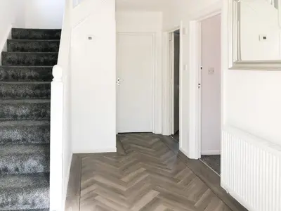 a hallway with white walls and a staircase with wooden floors at Wendover in Keswick