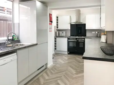 a kitchen with white cabinets and a black stove at Wendover in Keswick